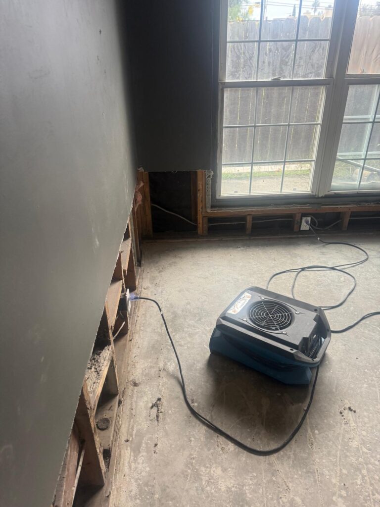Air mover drying a room where the lower wall was cut out by the window
