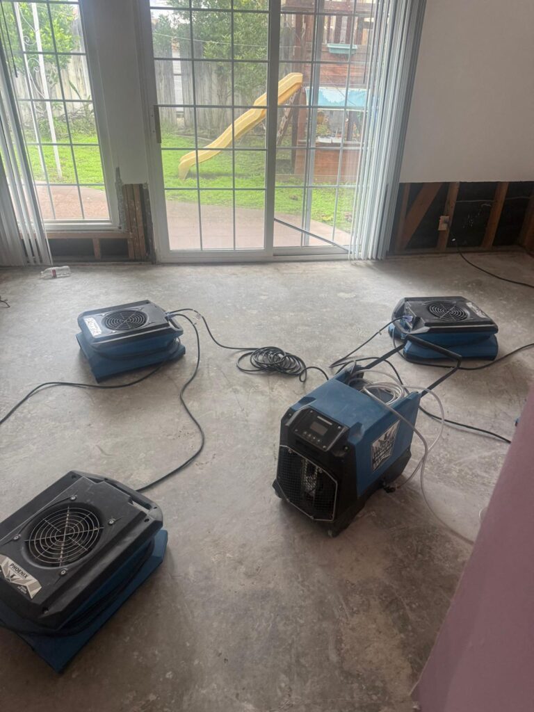 Dehumidifier and air movers drying a family room after water damage