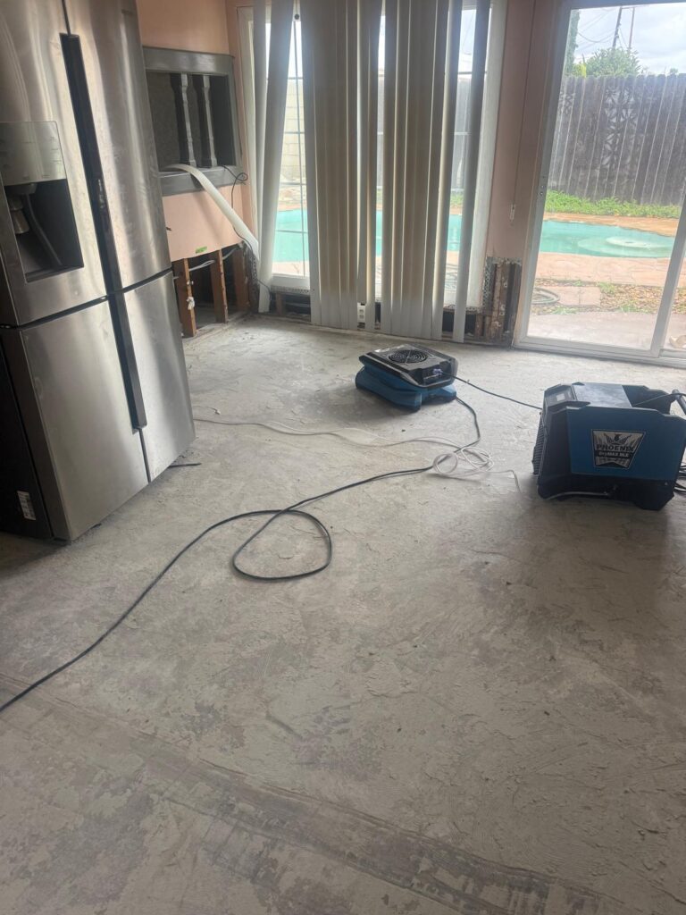 Dehumidifier and air mover drying a kitchen after water damage