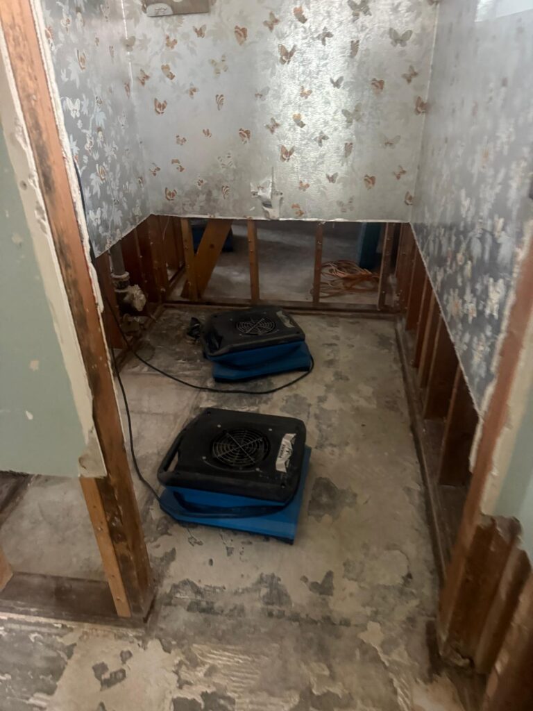 Two air movers drying a small room with the lower walls removed